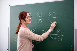 Smiling math teacher explaining new topic to her pupils